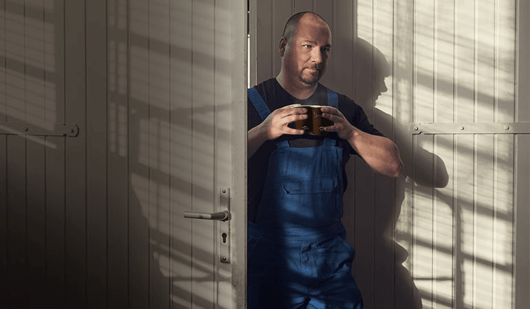 Mitarbeiter aus der Produktion trinkt einen Kaffee